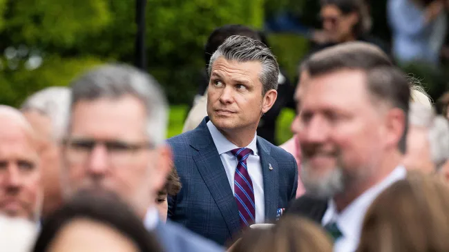 Secretary of Defense Pete Hegseth stands in a crowd